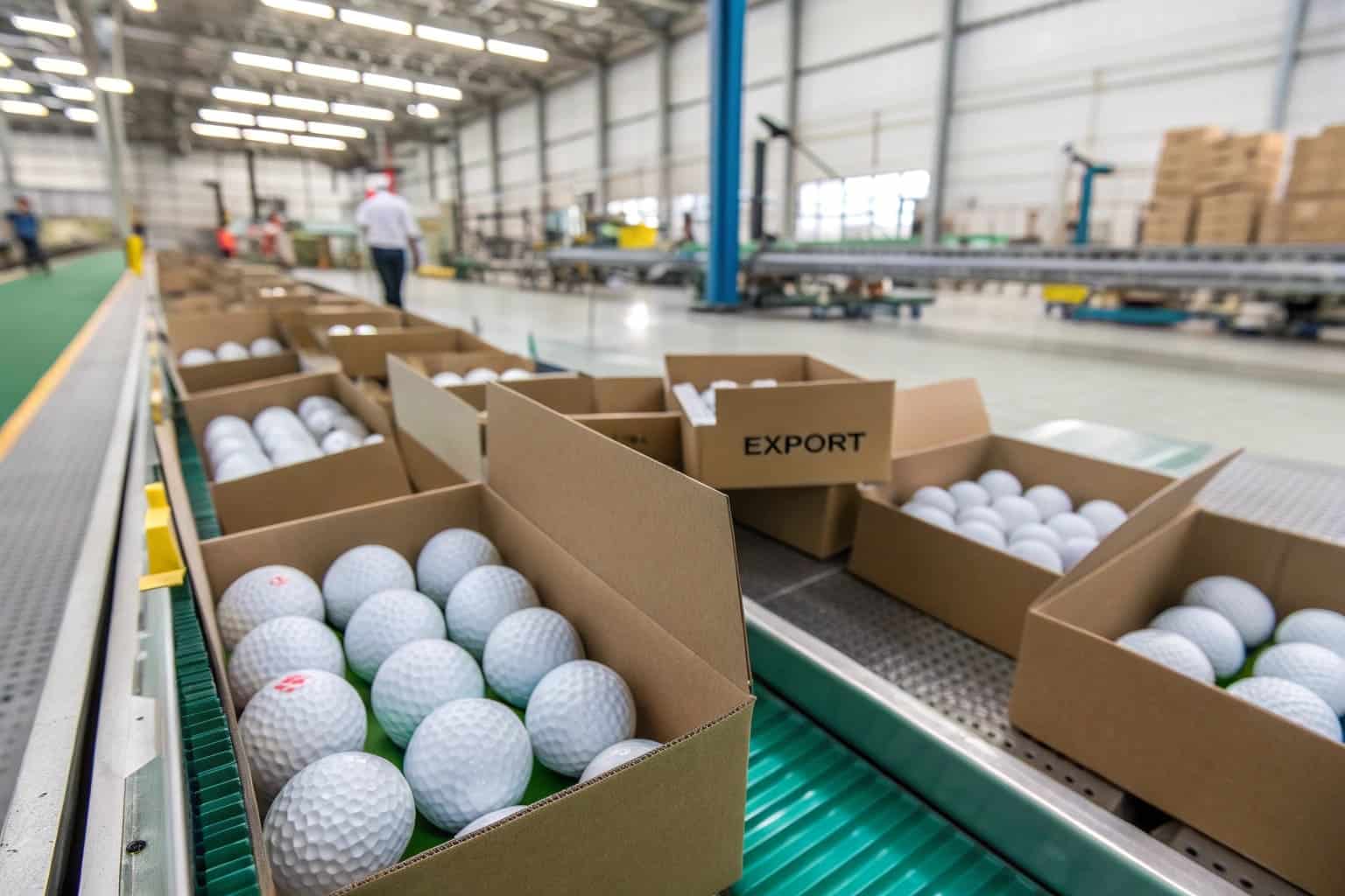 golf balls packed in cartons on factory conveyor for export